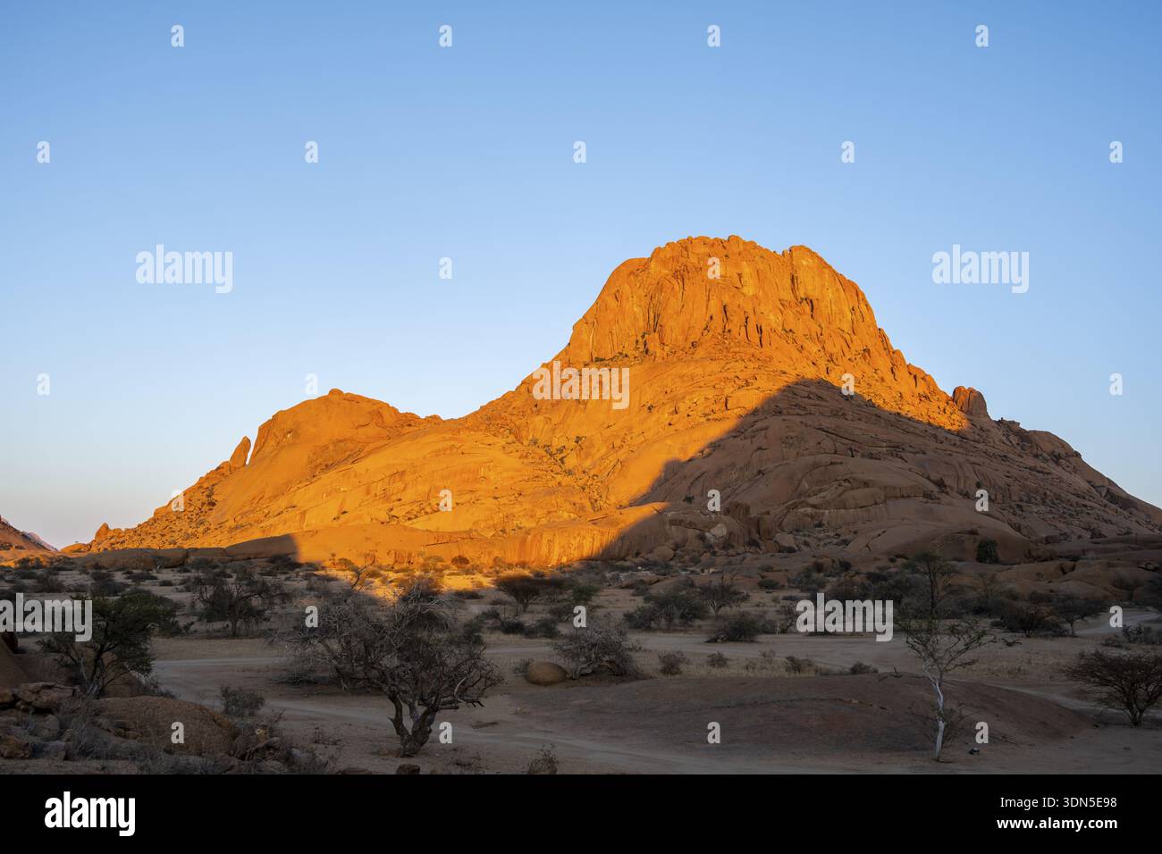 Rocks at sunset in the Namibian desert glow intensely orange, Spitzkoppe, Namibia Stock Photo