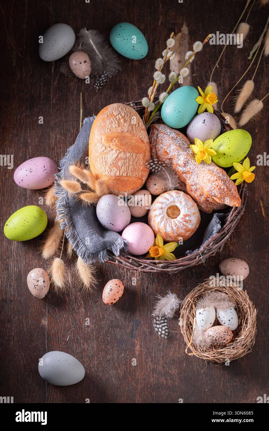 Traditional Easter basket with painted eggs, flowers and bread. Cake, catkins and Easter eggs for Easter. Stock Photo