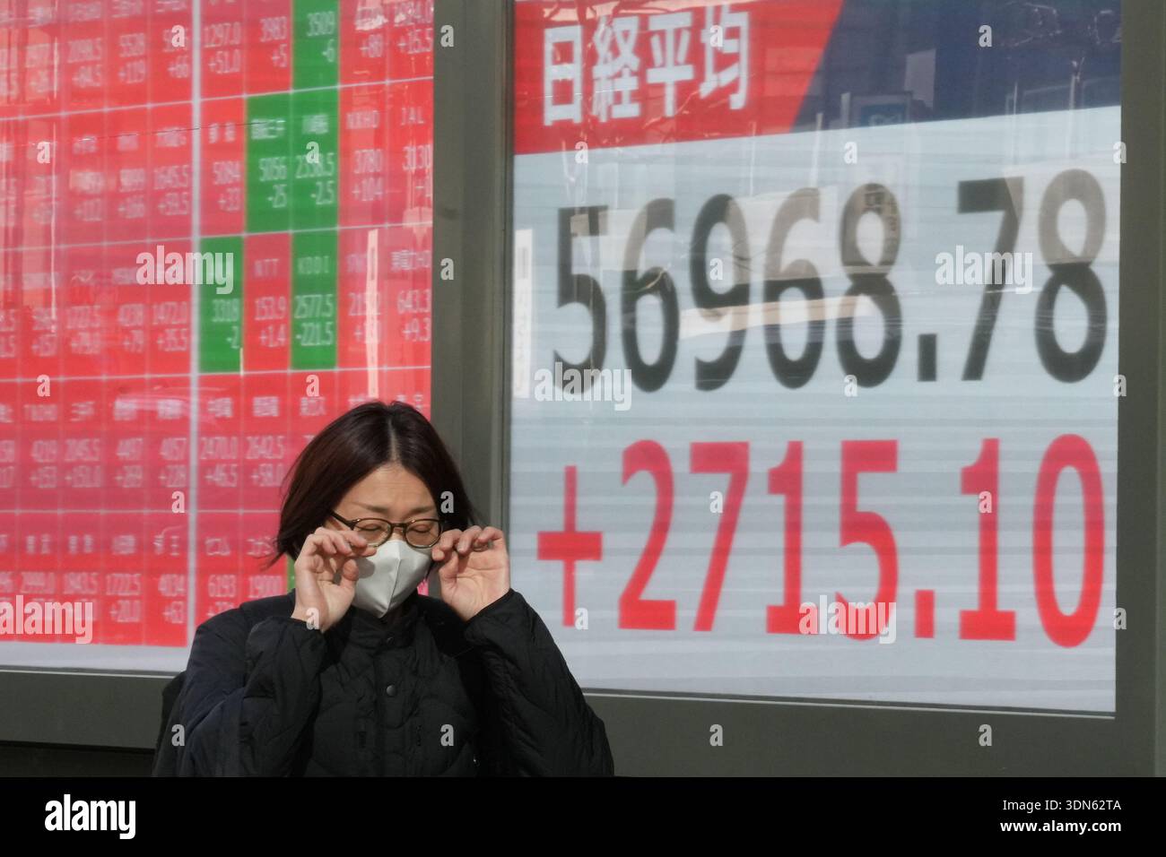A person walks in front of an electronic stock board showing Japan's ...