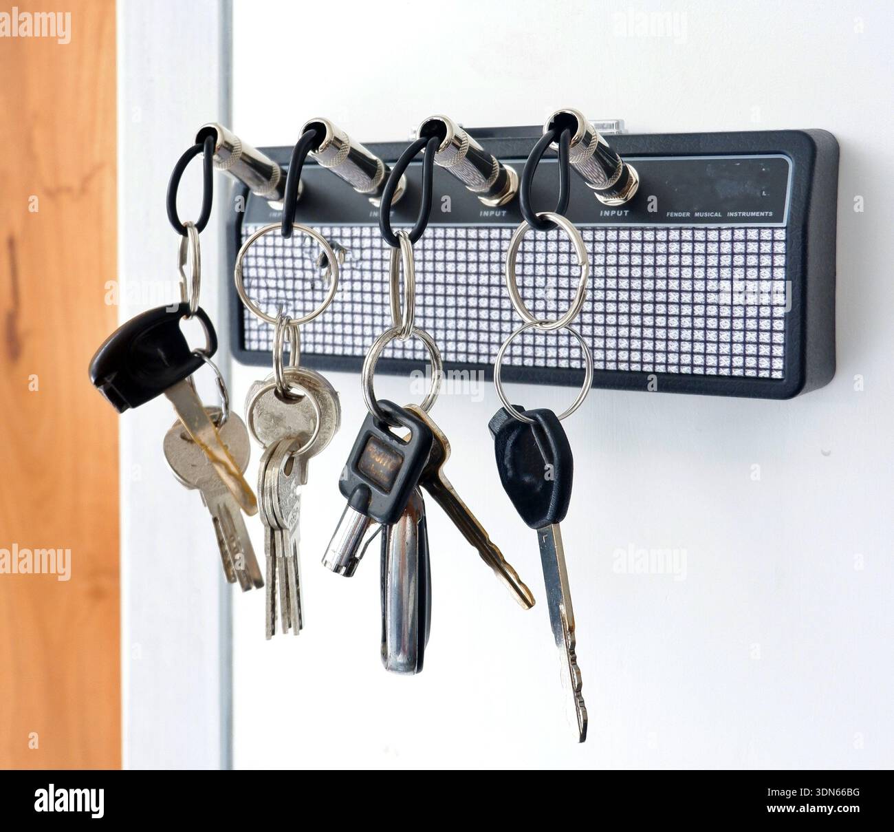 Creative Guitar Amp Key Holder with Jack Plug Keychains on White Wall Stock Photo
