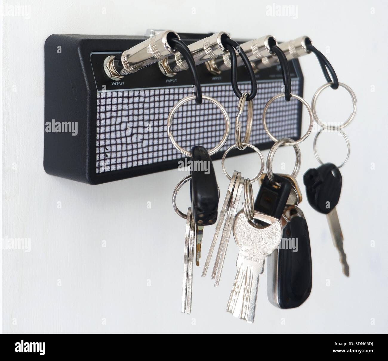 Creative Guitar Amp Key Holder with Jack Plug Keychains on White Wall Stock Photo