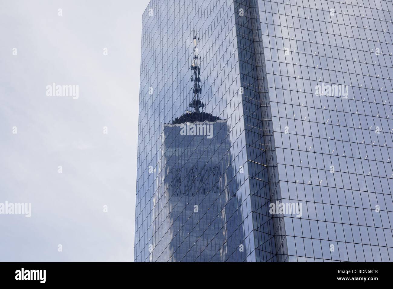 The iconic spire of One World Trade Center reflected in the glass ...