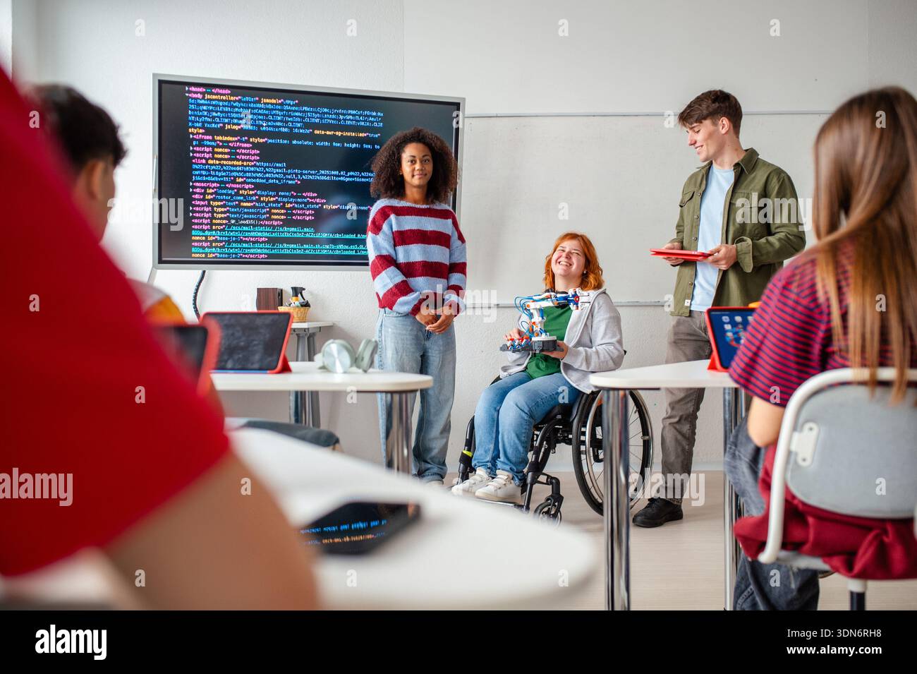 Inclusive student team presenting technology project in class. Stock Photo