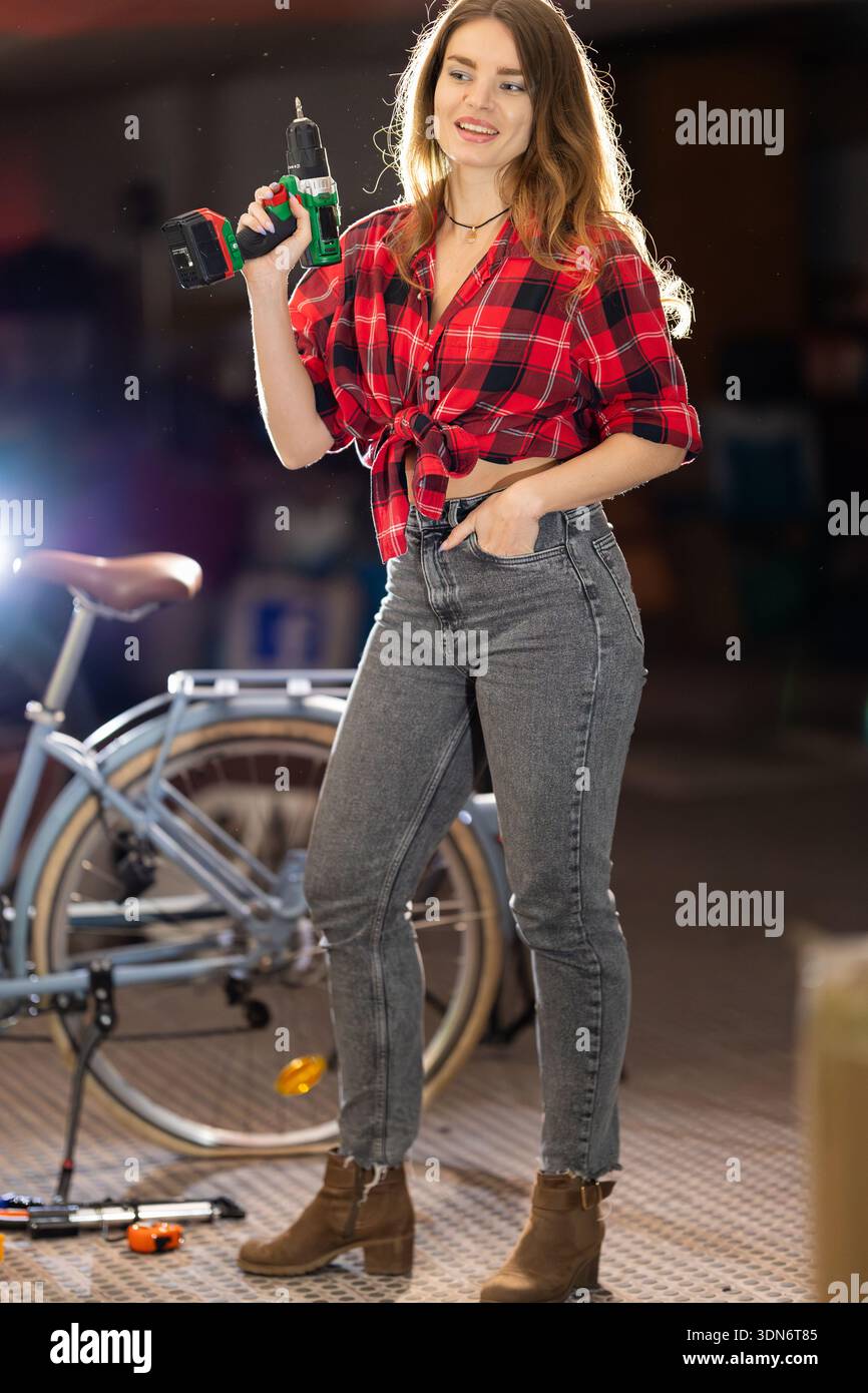 Young woman holding drill working in workshop Stock Photo