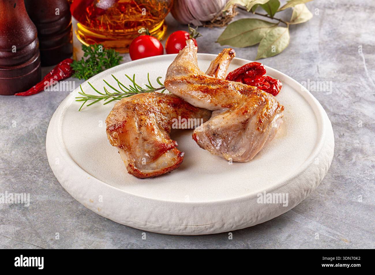 Roasted rabbit leg served rosemary in the plate Stock Photo - Alamy