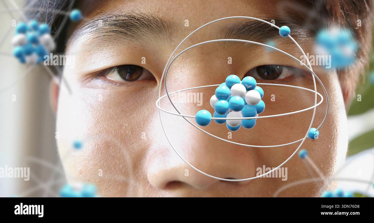 Framing mid adult Asian male face inside room, showing AR molecular model orbiting right eye Stock Photo