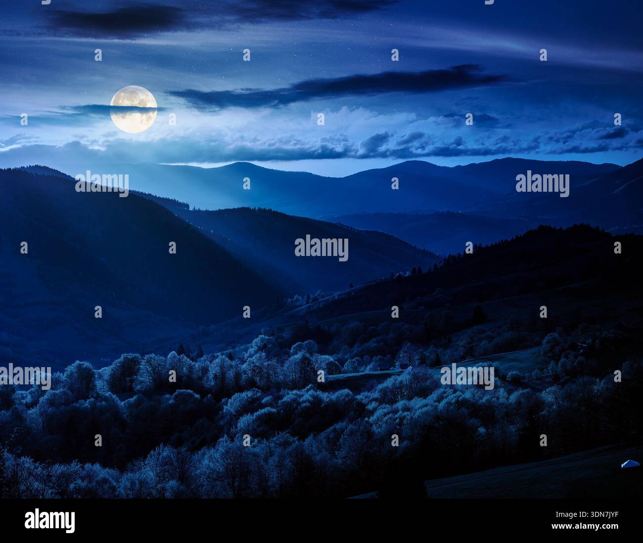 gorgeous countryside in spring at night. beautiful mountain landscape with cloudy sky over the forested rolling hills in full moon light. mysterious s Stock Photo