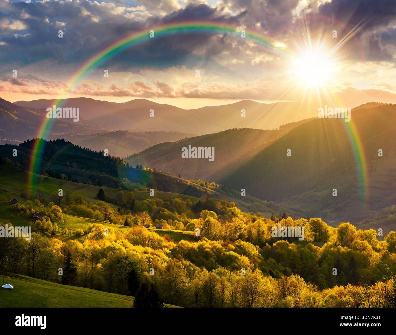 gorgeous countryside in spring at sunset. beautiful mountain landscape with cloudy sky over the forested rolling hills in evening light. scenery with Stock Photo