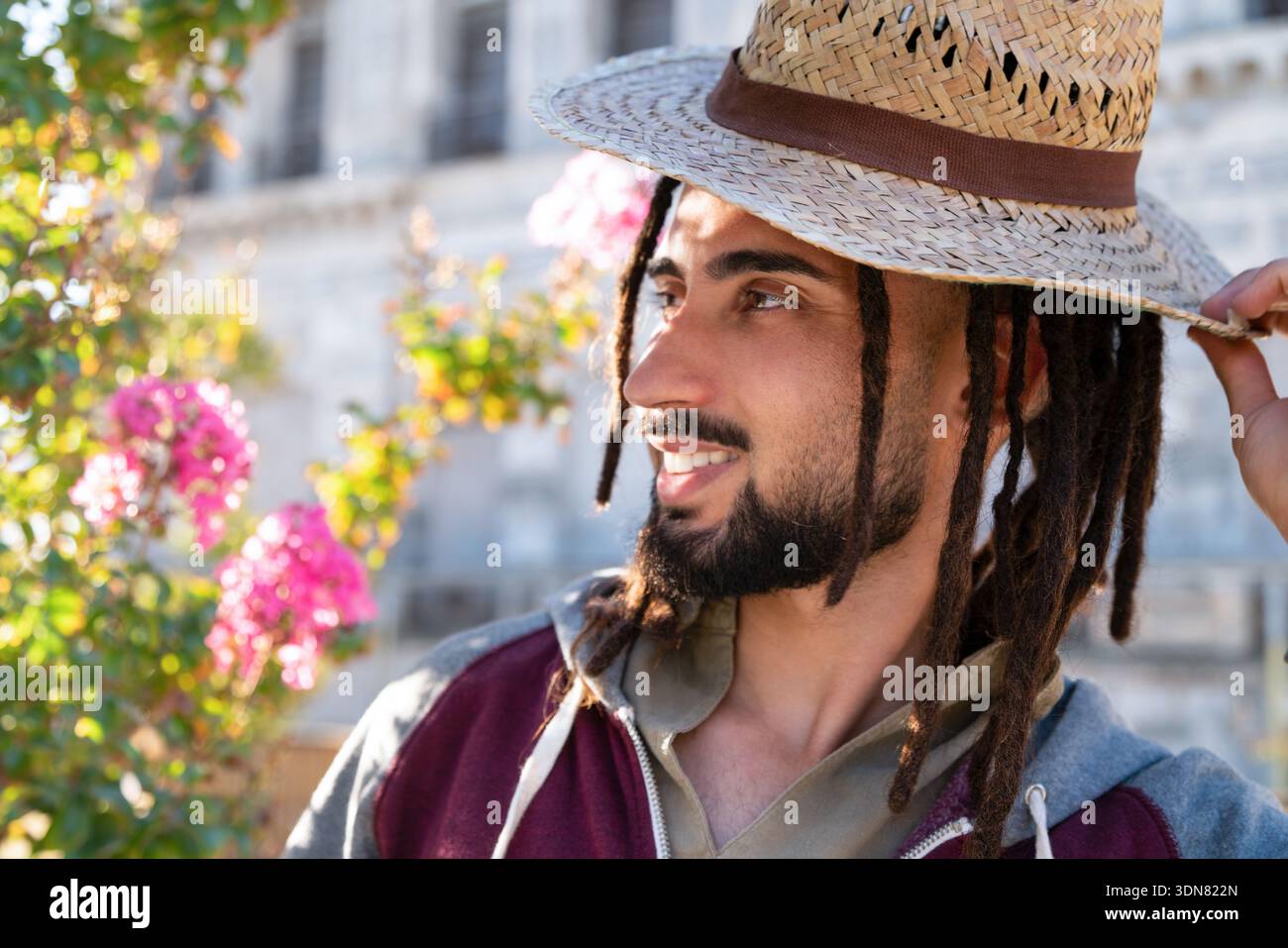 Young man wearing a straw hat with dreadlocks with Stock Photo