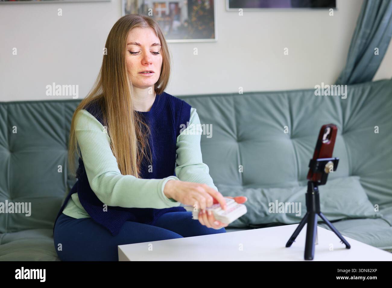 Tarot card reader holding card during online consultation on smartphone Stock Photo