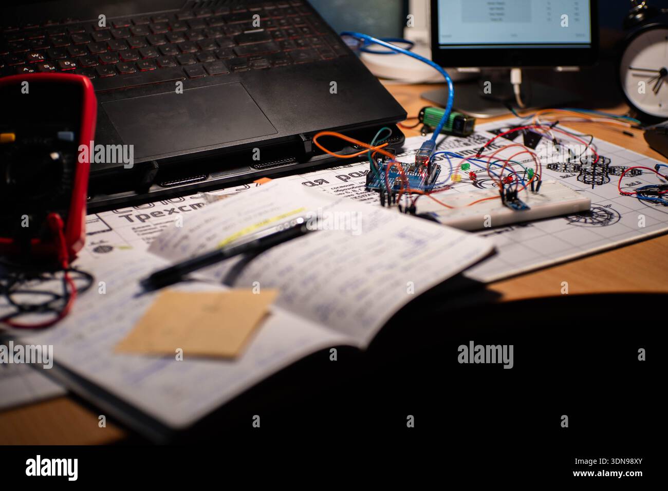 Multimeter Notebook A detailed view of an electronics workbench setup, showing circuit ...