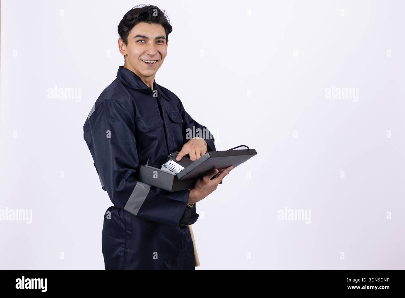 Professional technician holding a tablet and a tool Stock Photo