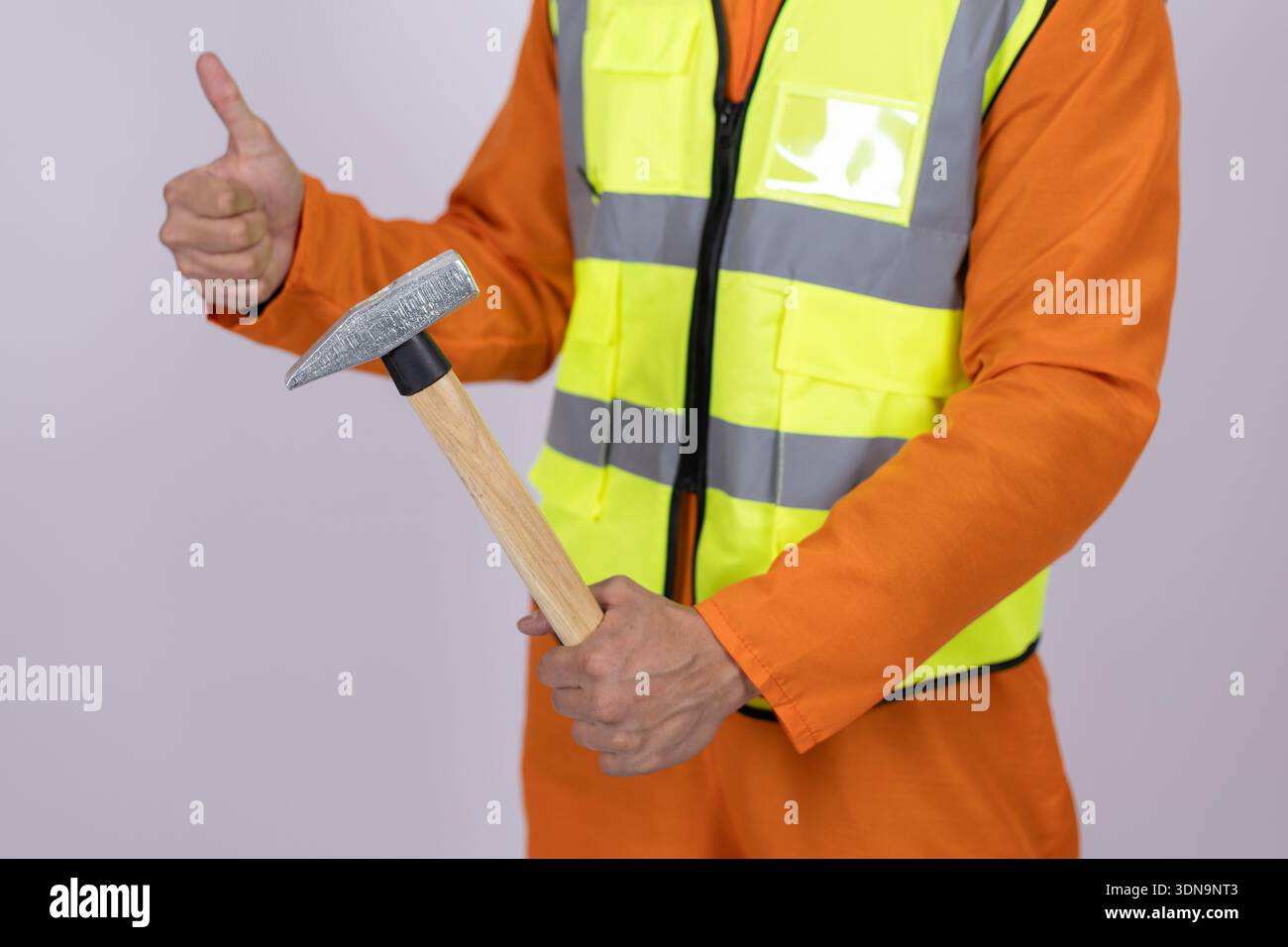 Construction worker holding a hammer in studio Stock Photo