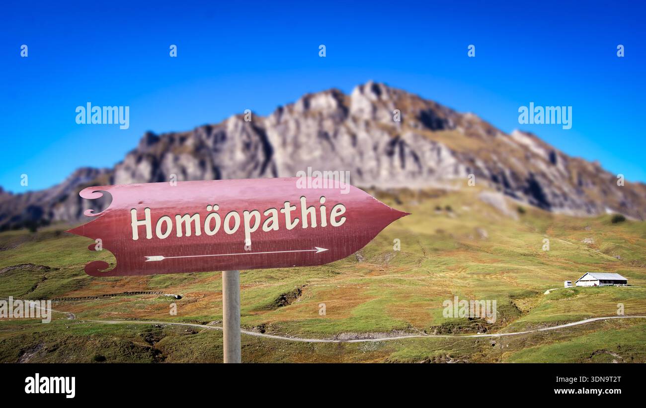 The picture shows a signpost and a sign that points in the direction of homeopathy in German. Stock Photo