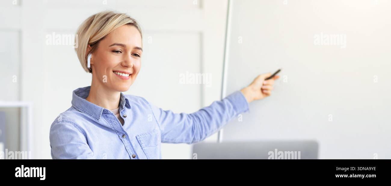 Woman Teaching and Explaining Concepts in a Modern Office Space While Smiling Stock Photo