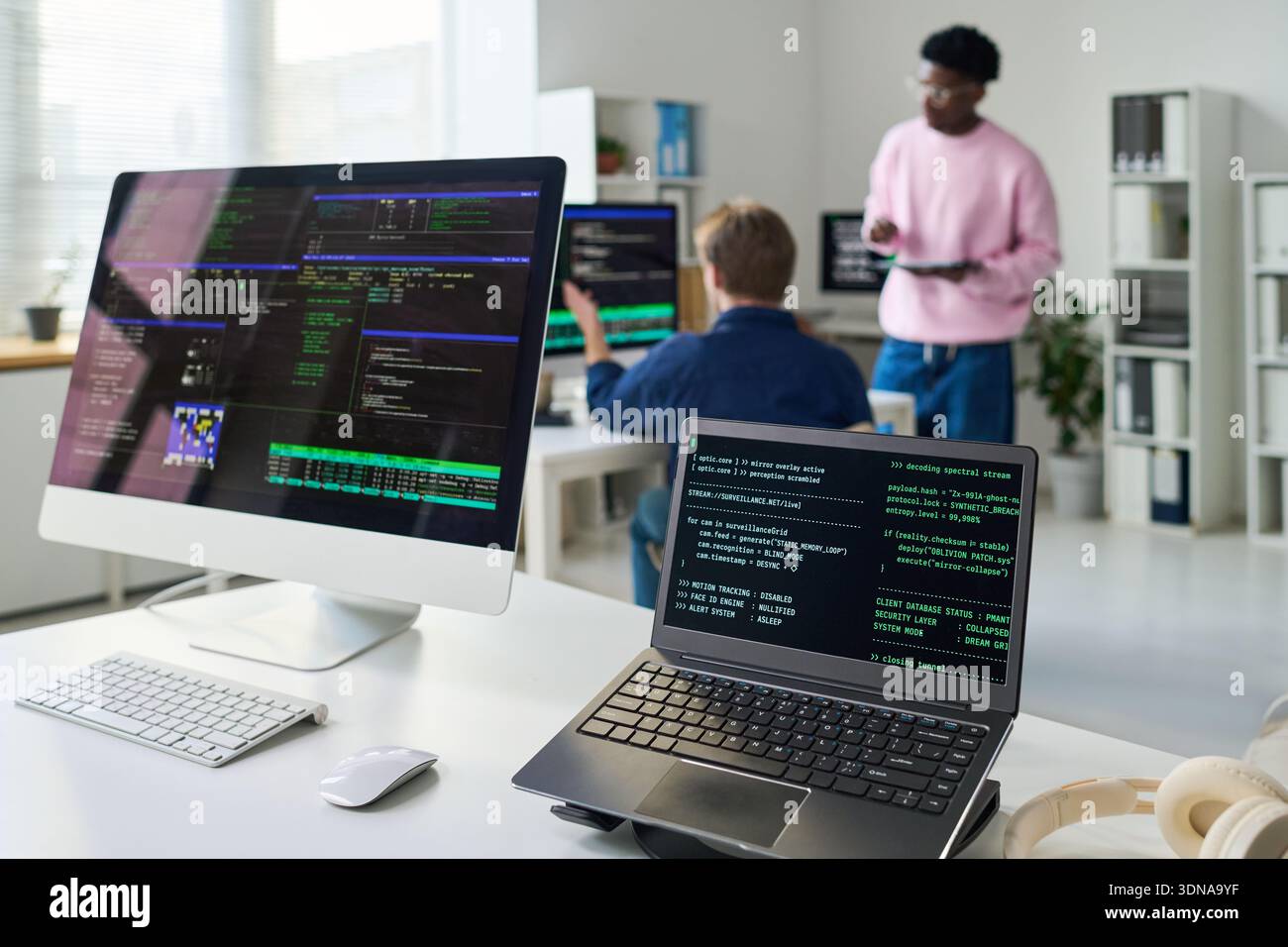 Young Man and Black Man Collaborating on Software Development Project Stock Photo