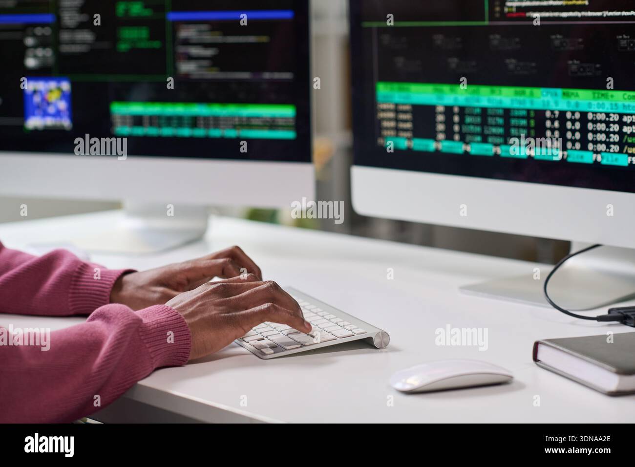 Young Black Woman Typing Code on Computer in Office Setting Stock Photo