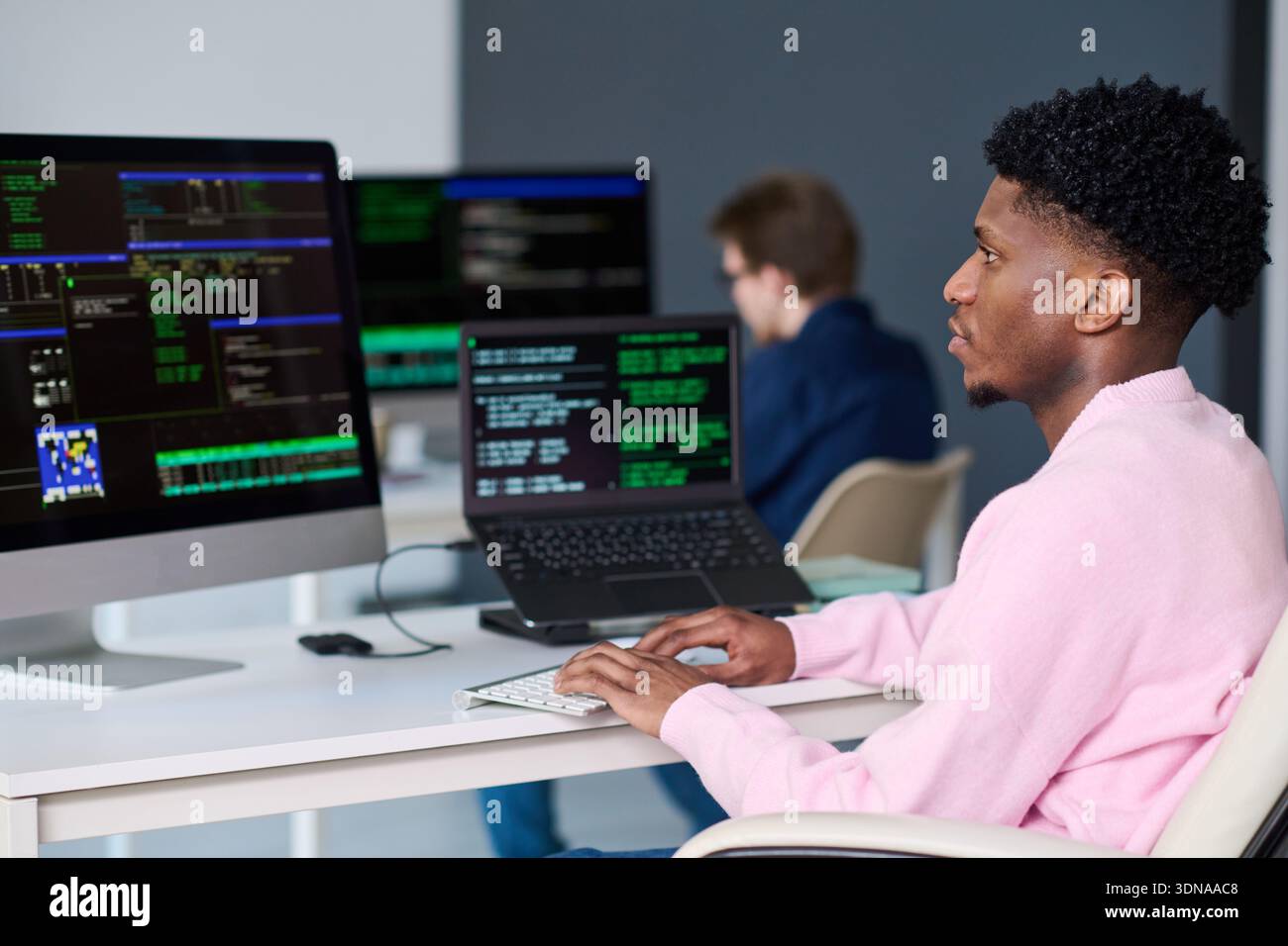 Young Black Man Working on Computer in Office Environment Stock Photo
