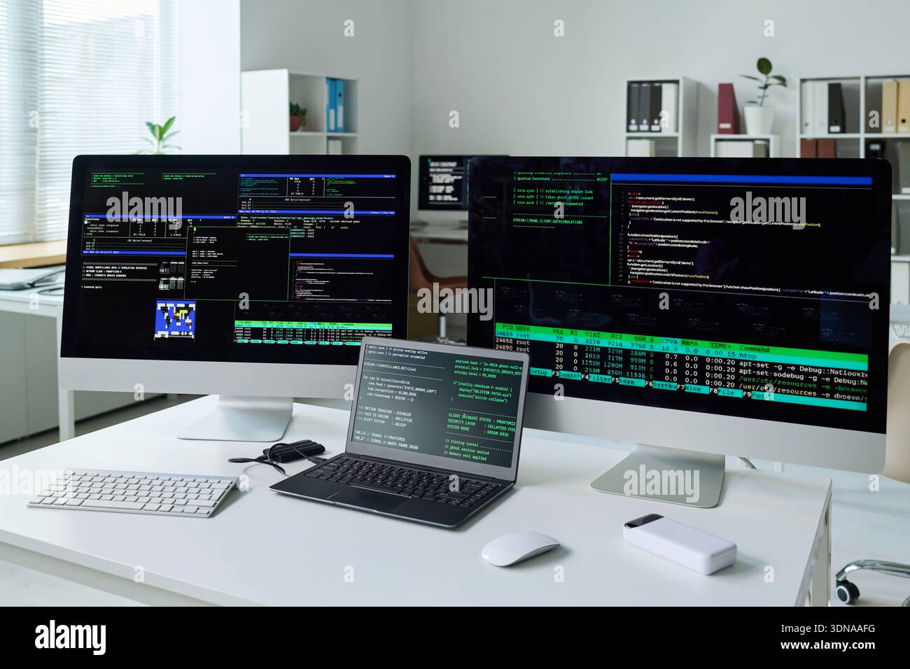 Multiple Computer Monitors Displaying Software Development and Coding Process Stock Photo