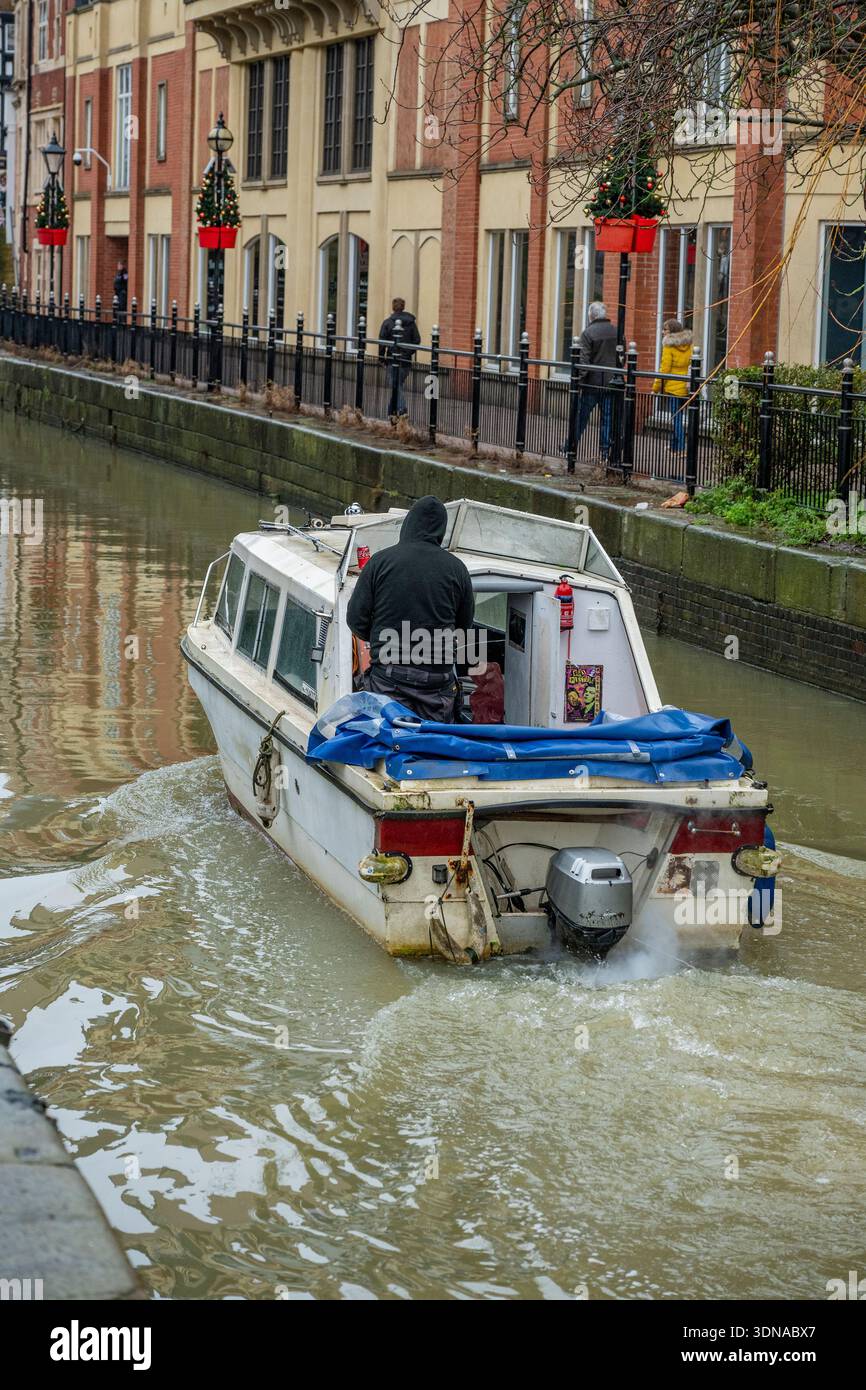 Man cruising along the River Witham in Lincoln city centre on an old ...