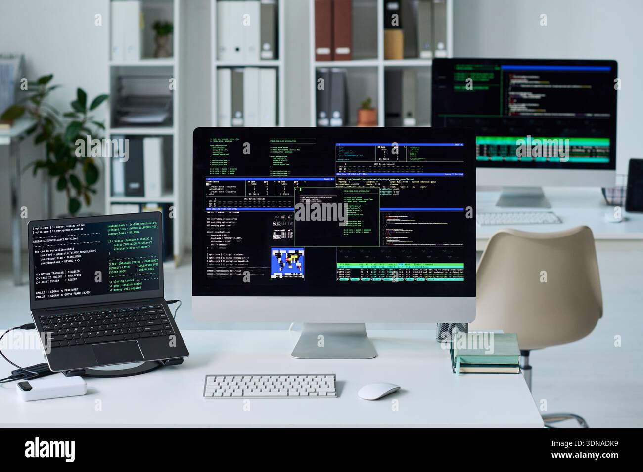 Office Desk Displaying Computer Screens Running Programming Code Stock Photo