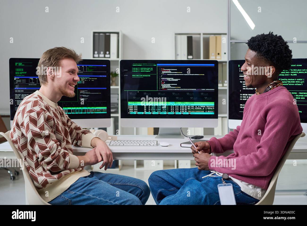 Young Men Collaborating in Office While Discussing Software Development Stock Photo