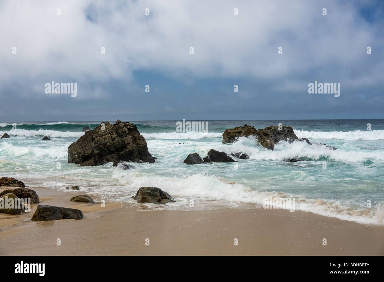 Boulders In The Surf Break Up Waves On A Stormy Day on Big Sur Coast Stock Photo