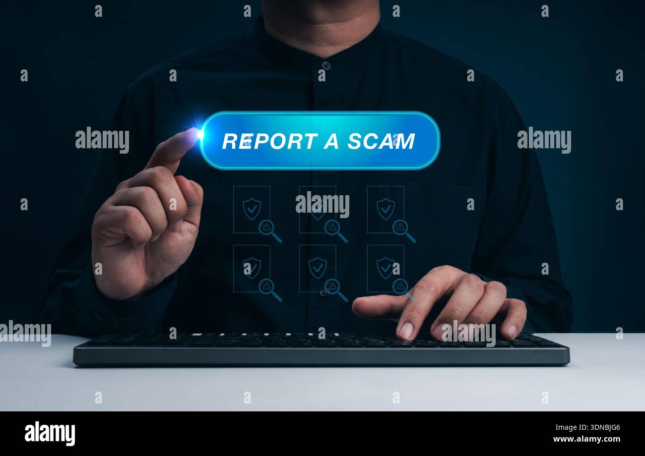 Man pressing Report a Scam button on virtual interface while using computer. Online fraud prevention, internet scam alert, cybersecurity awareness, an Stock Photo