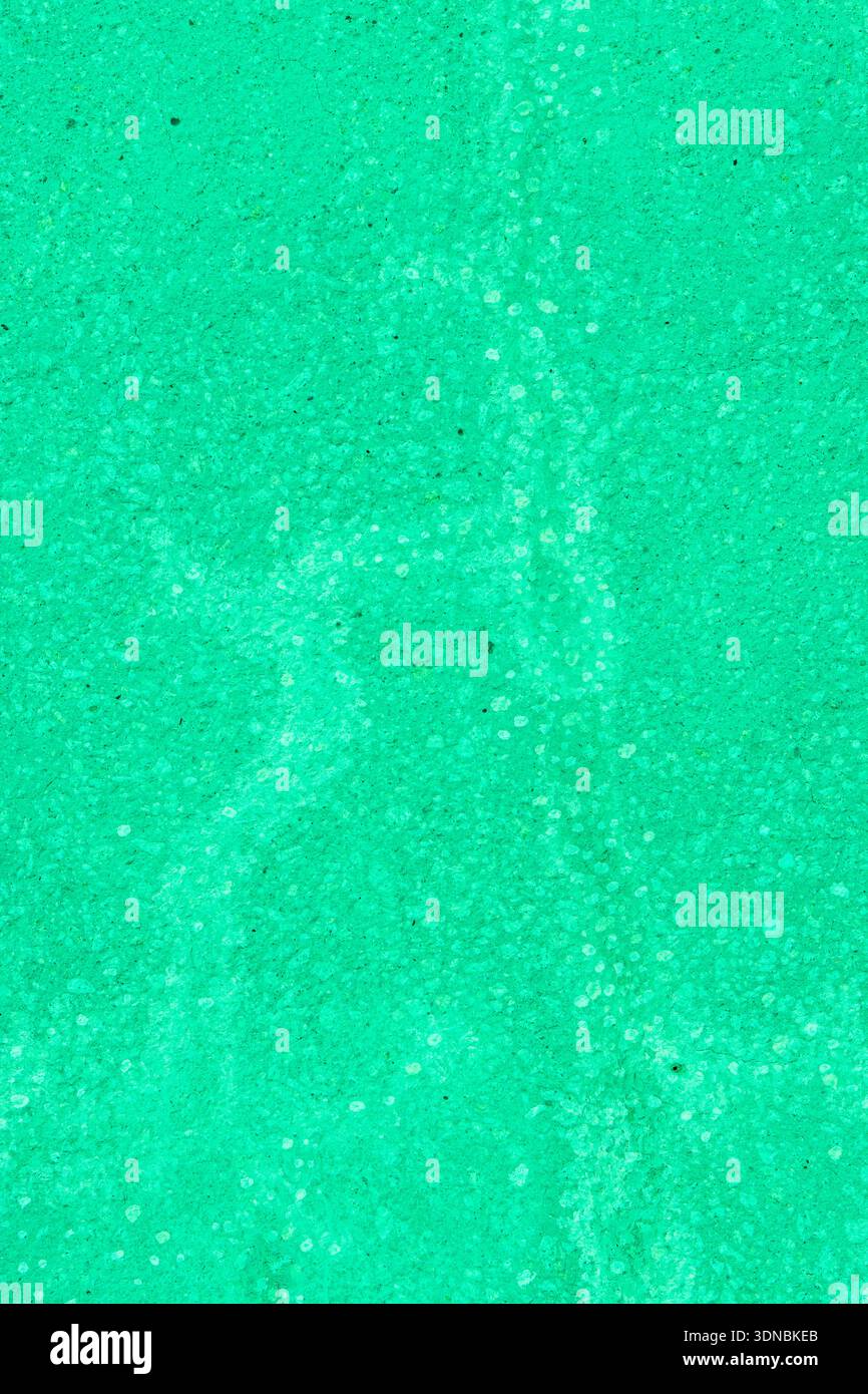A green concrete wall with painted-over cracks. Stock Photo