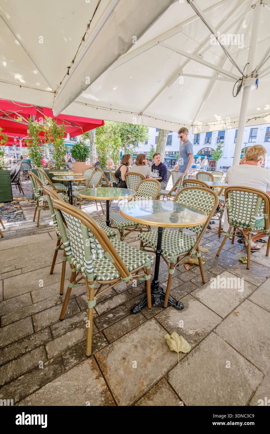 Outdoor Cafe Terrace with Traditional Green Wicker Chairs, Round Marble Tables Stock Photo
