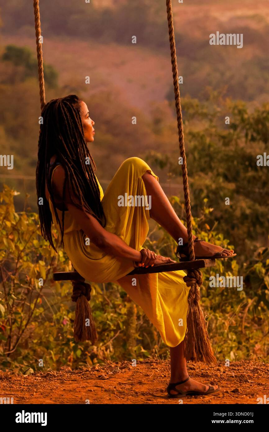 Woman on swing at restaurant watching sunset in mountains NW of Nosara town, a popular area of the north Pacific coast. Nosara, Guanacaste, Costa Rica Stock Photo
