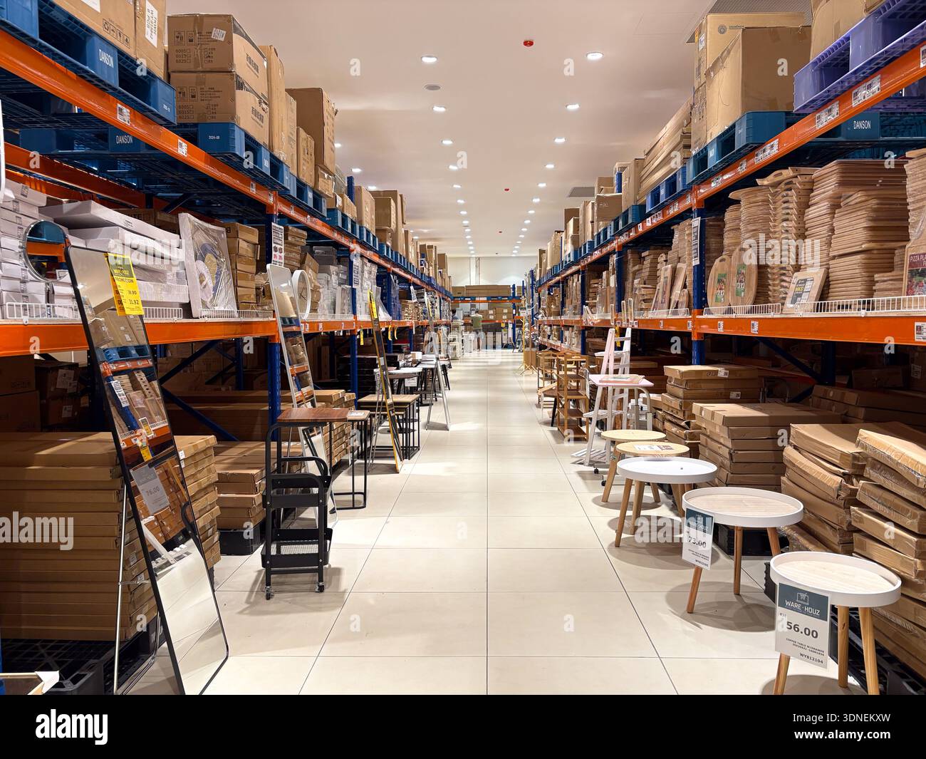 Kelantan, Malaysia - February 7, 2026. An interior view of a high ceilinged furniture warehouse with orange industrial racking storing boxed inventory - Smartphone Captured Stock Image