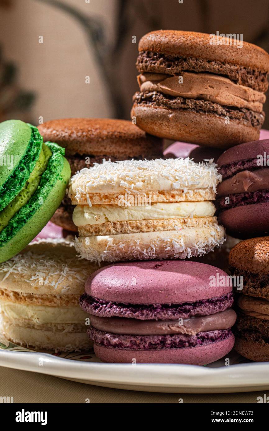 Assorted macarons stacked on decorative plate Stock Photo