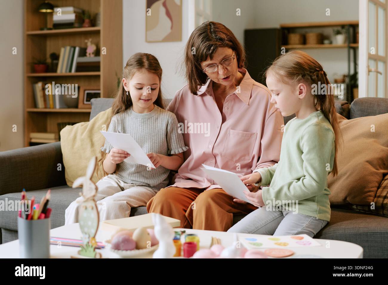 Middle Aged Woman Teaching Two Girls Reading Documents Stock Photo