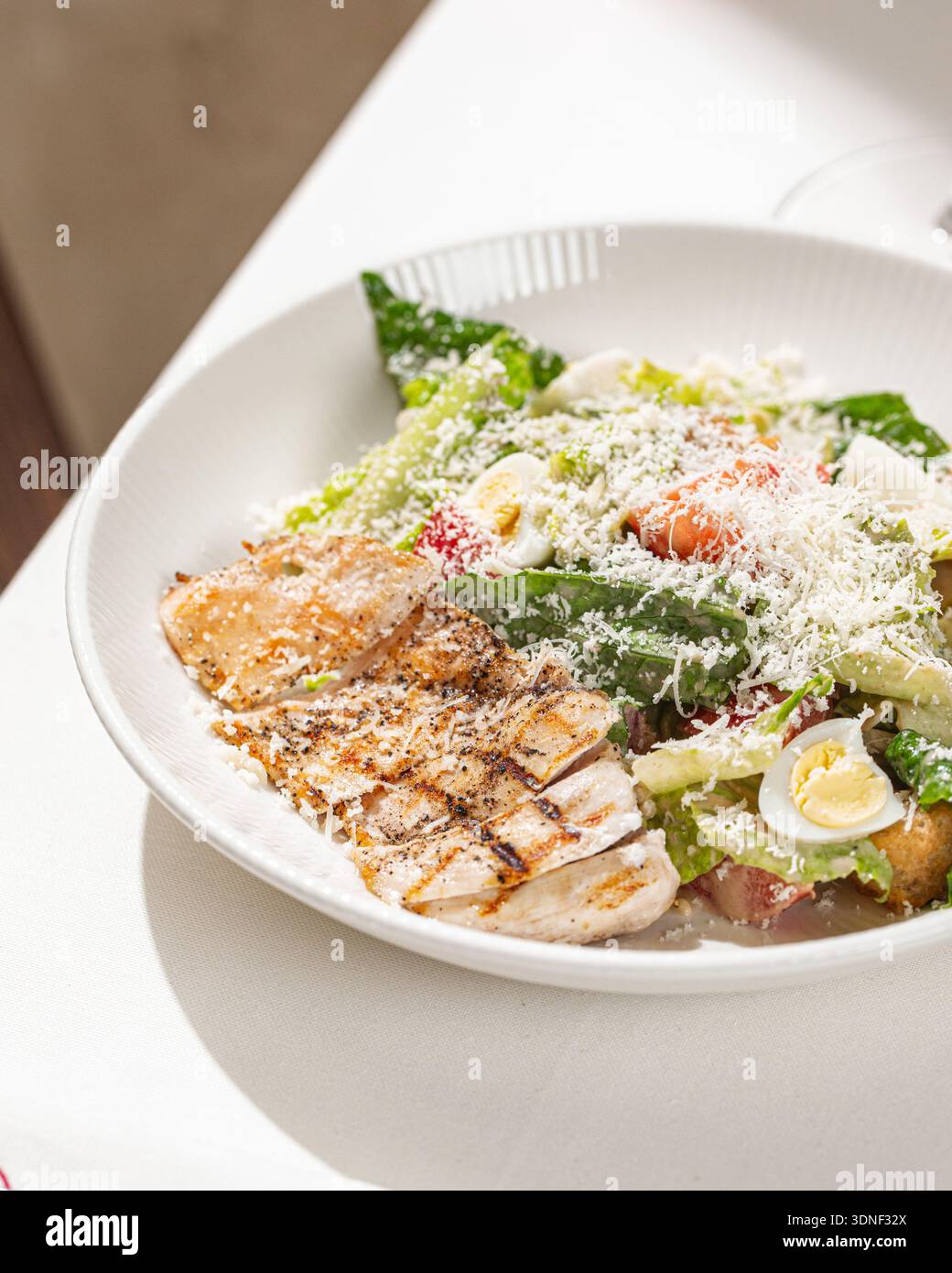 Caesar salad with grilled chicken and parmesan Stock Photo