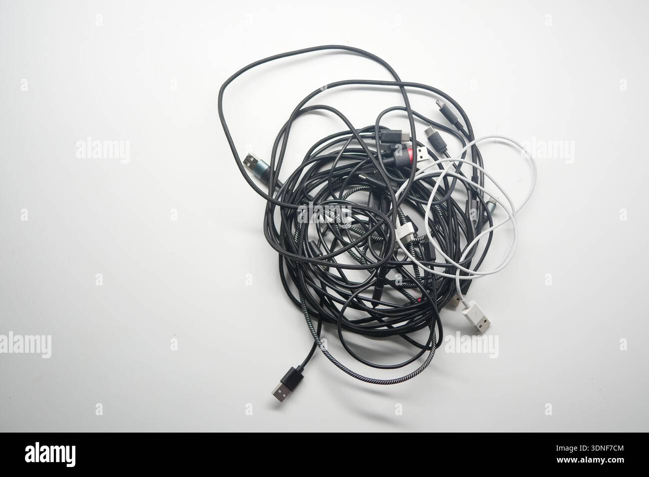 Multiple tangled charging cables on a white background Stock Photo