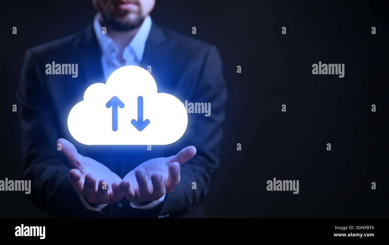 Man holds cloud symbol with arrows for file transfer in dark background Stock Photo