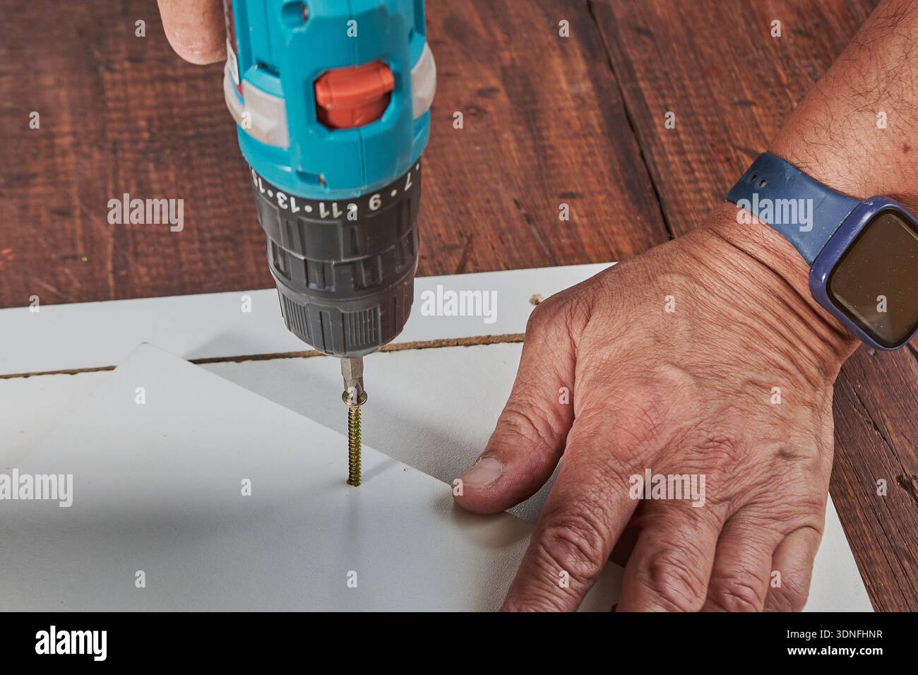 Handyman using power tool for home repair and carpentry work Stock Photo