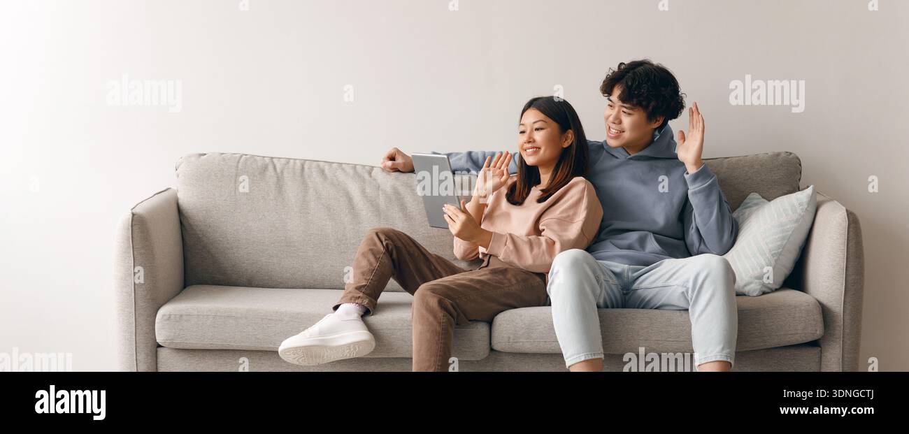 Couple Enjoying Time Together on Sofa While Using Tablet Stock Photo