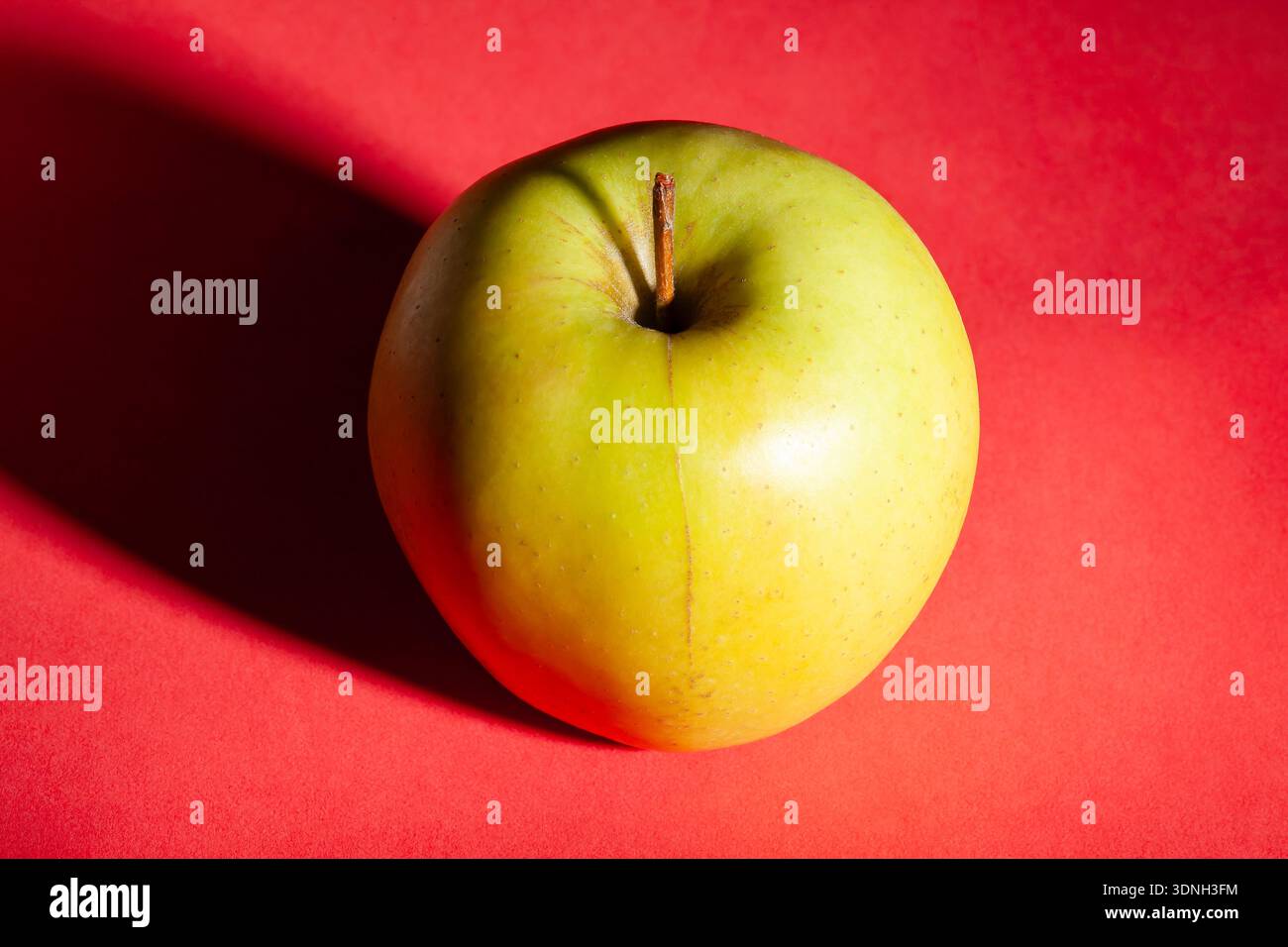 yellow apple on red background Stock Photo