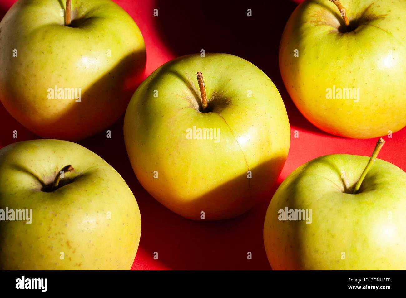 yellow apple on red background Stock Photo
