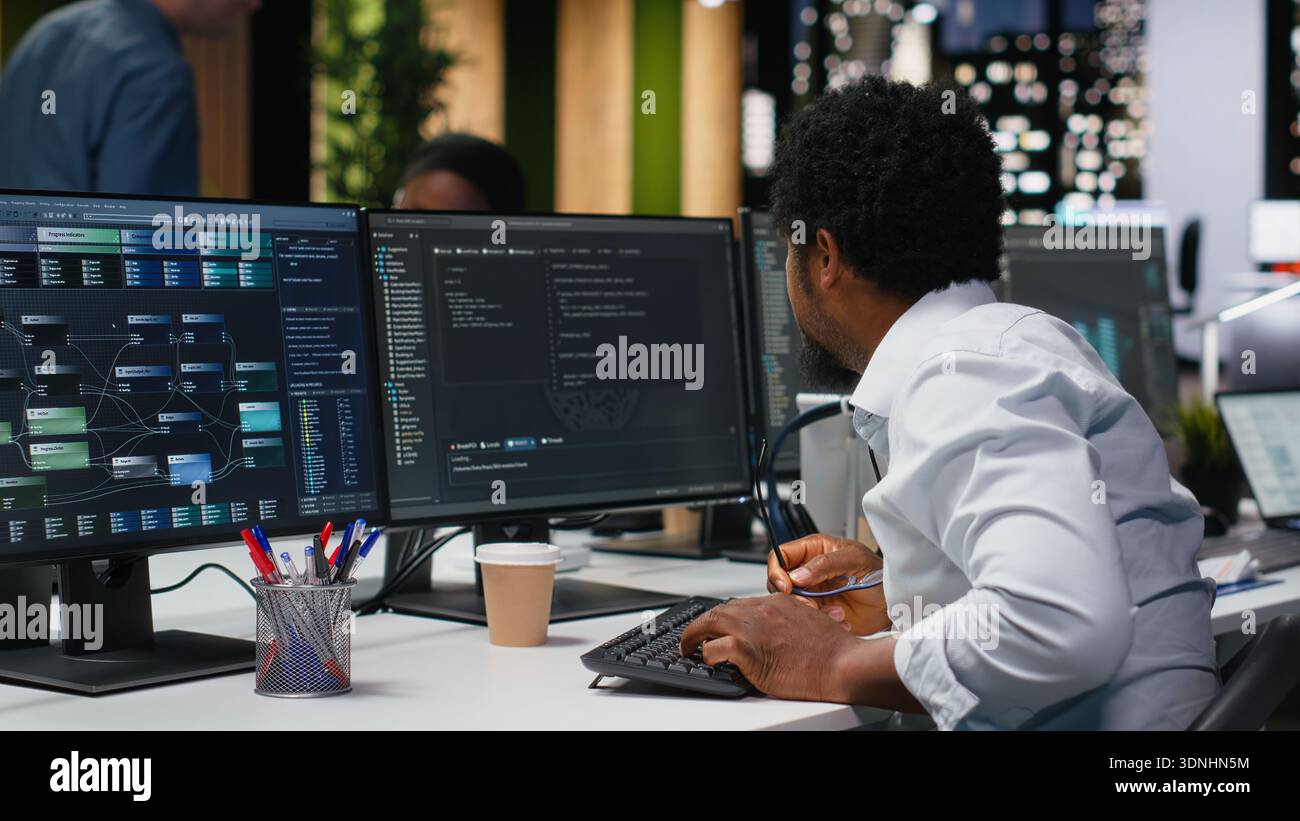 Engineer in Silicon Valley company office developing apps with AI. IT professional using machine learning to do coding, debugging applications to resolve issues Stock Photo