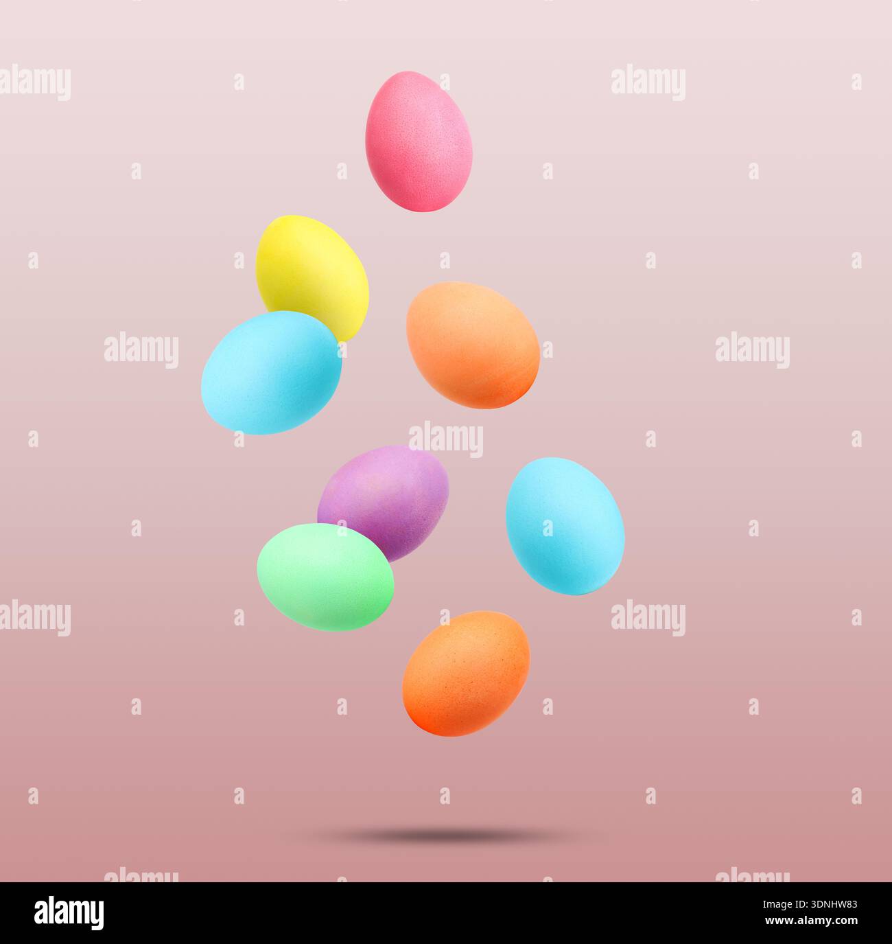 Easter eggs brightly dyed for holiday falling against red gradient background Stock Photo