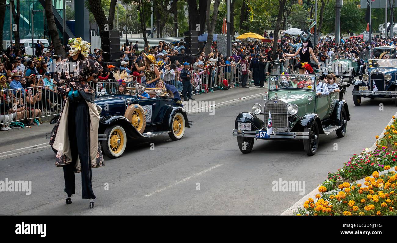 People in vintage cars and on stilts parade on the Day of the Dead in Mexico City, Mexico Stock Photo