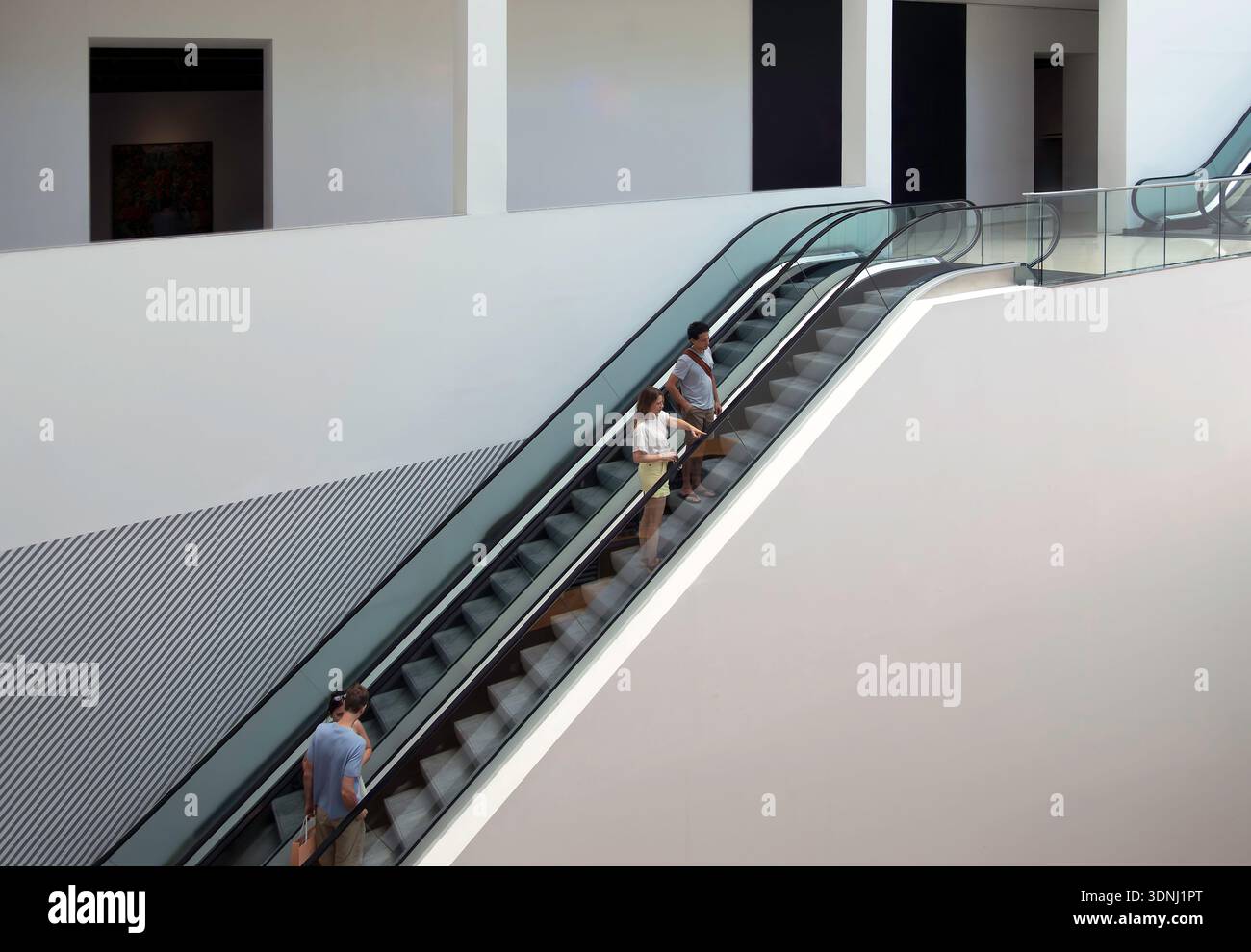 People on escalator in building interior Stock Photo
