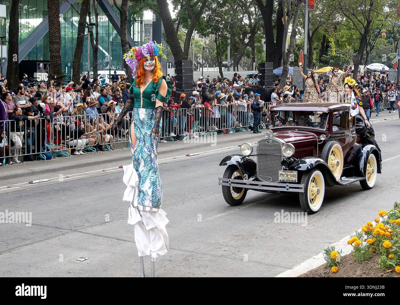 People on stilts and vintage cars parade on Day of the Dead celebrations in Mexico City, Mexico Stock Photo