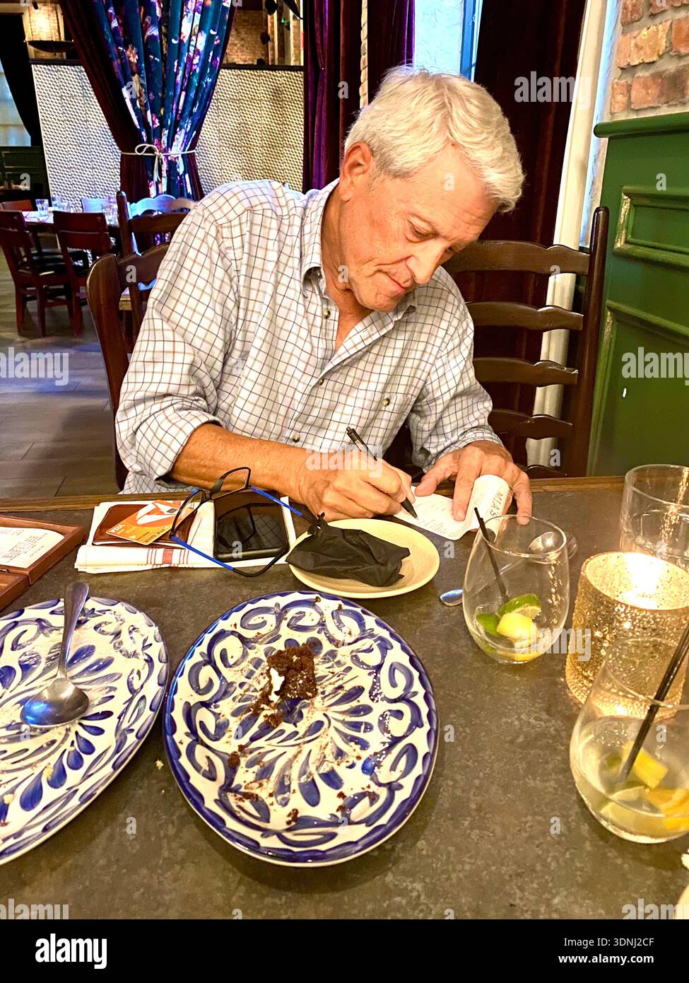 Senior man paying the bill at a restaurant with a credit card, model released. - Smartphone Captured Stock Image