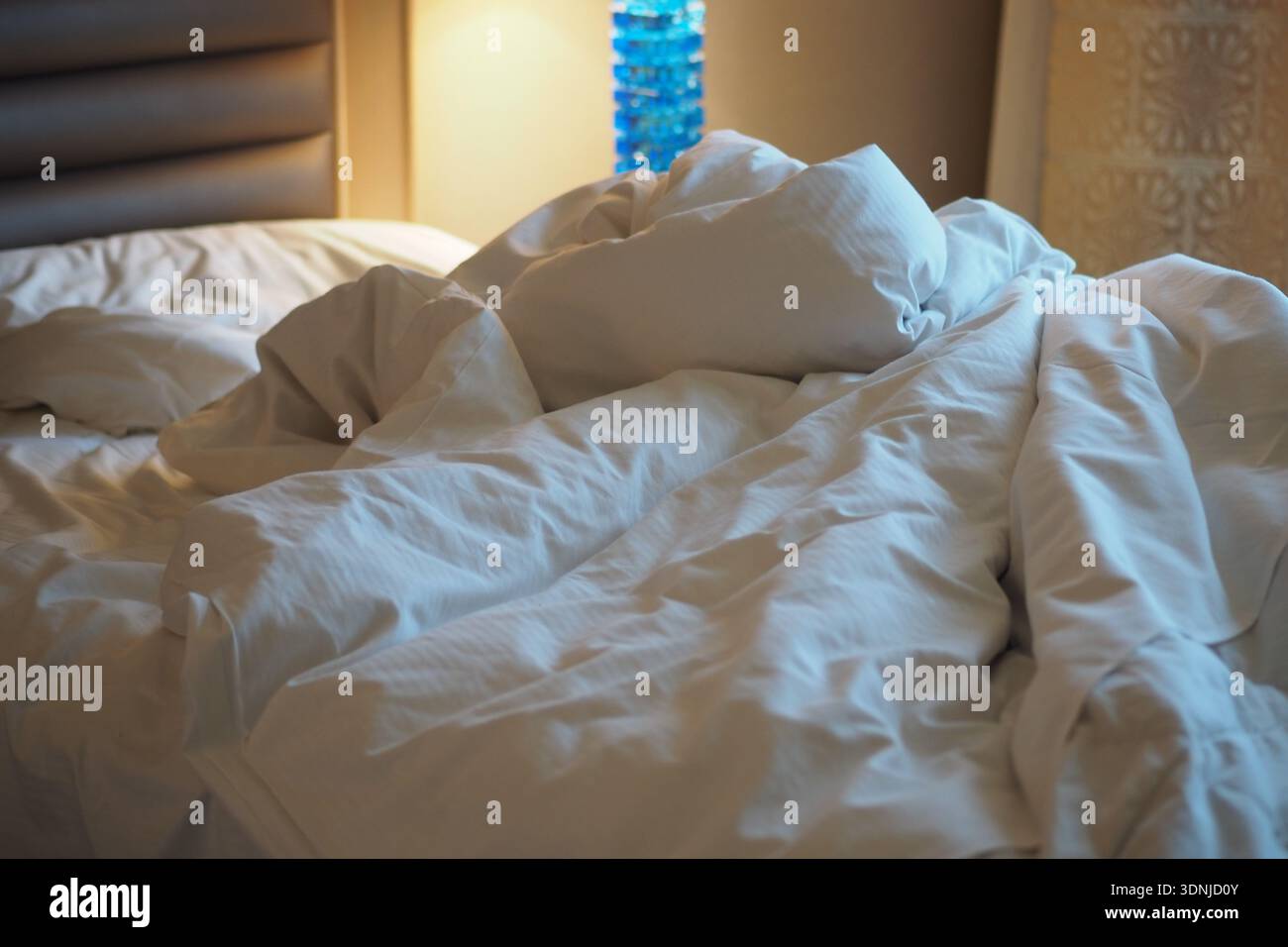 Bedding on a hotel bed after guests checked out Stock Photo