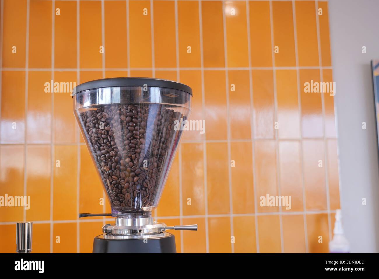 Coffee grinder with beans in cafe setting Stock Photo