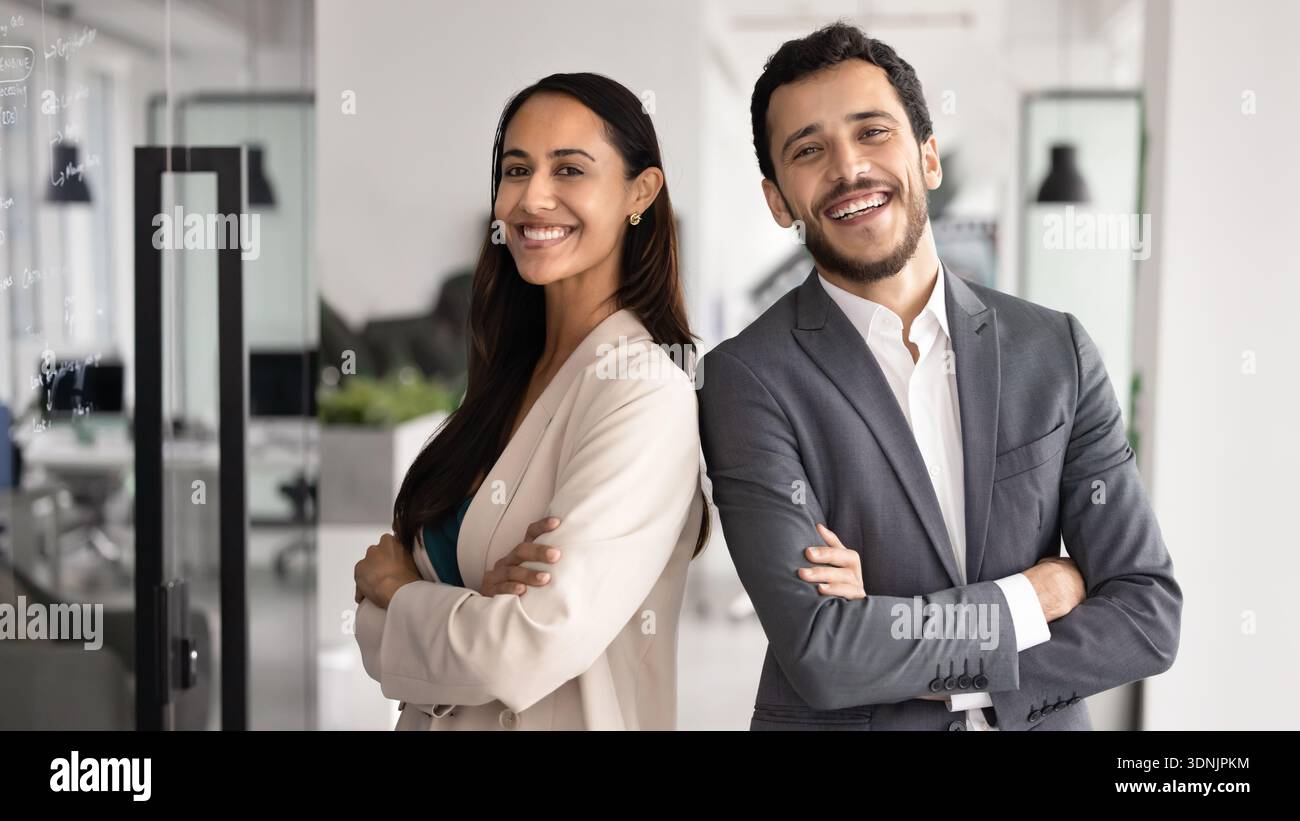 Two multiethnic teammates posing in modern office Stock Photo